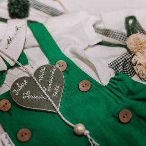 Charming children's clothing featuring green details, buttons, and a heart accent for a rustic look.